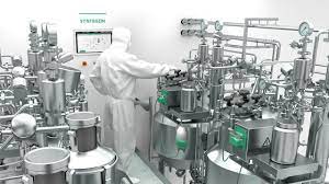 Person in protective suit working on a pharmaceutical machine