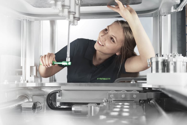 Female technician working on industrial equipment.