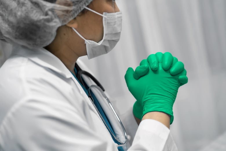 Laboratory worker in protective gear handling sterile equipment.