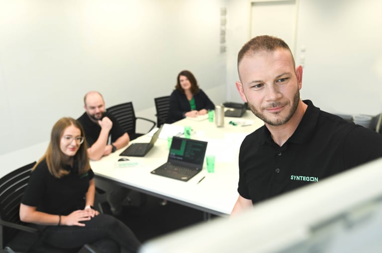Syntegon experts in a meeting room discussing GMP-compliant production processes
