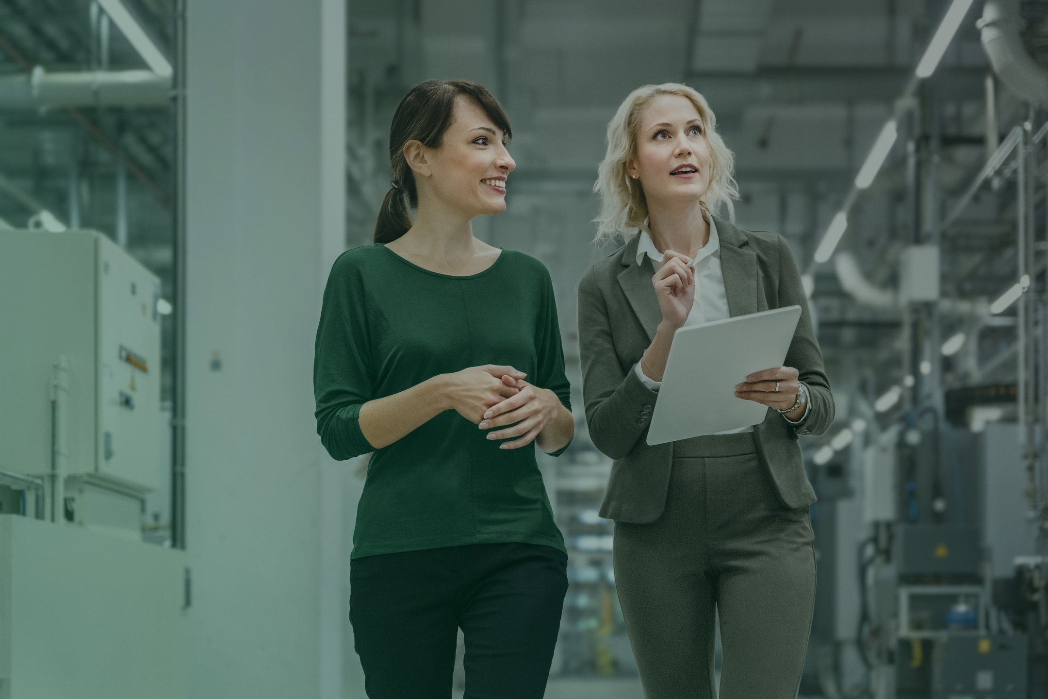 Eine Geschäftsfrau arbeitet gemeinsam mit einem Kollegen in einer modernen Fabrik.