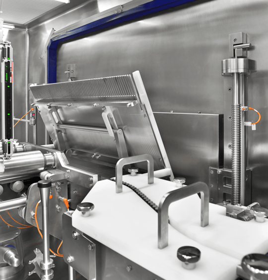 Close-up view of a modern pharmaceutical lyophilizer integrated into an aseptic production line, showcasing advanced equipment for freeze-drying processes in the biotech and pharma industries.